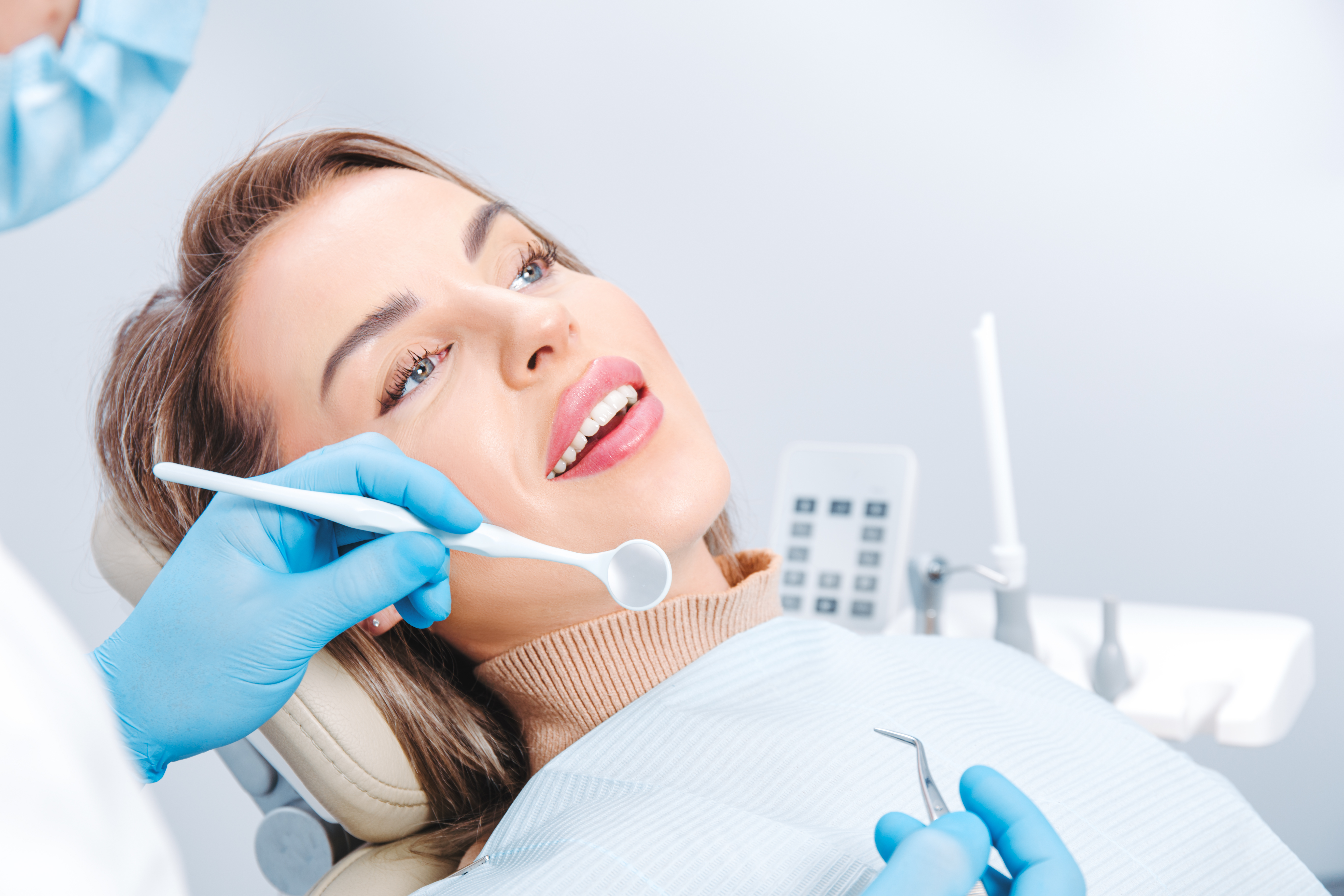 attractive-smiling-woman-at-the-dentist-appointmen-2022-11-29-20-24-13-utc